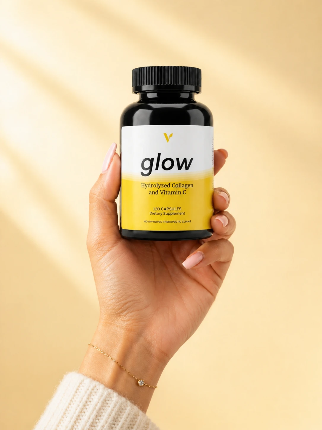 A hand holding the complete Glow bottle in warm sunlight